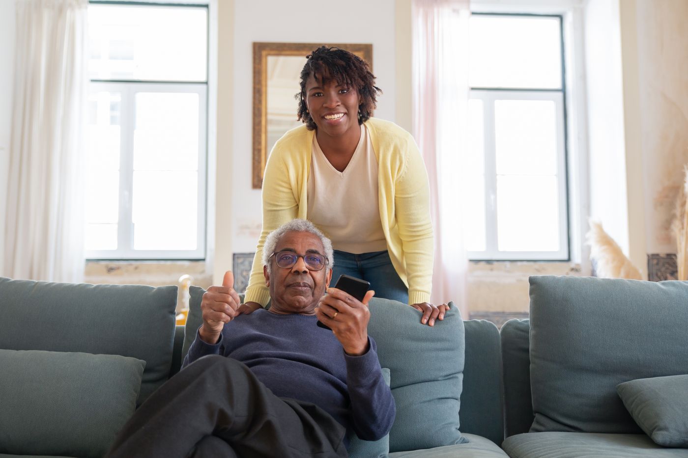 A PureCare caregiver checking in with a client at home while family looks on